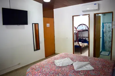 a bedroom with a bed with two towels on it at Volcano Hostal y Restaurante in San Salvador