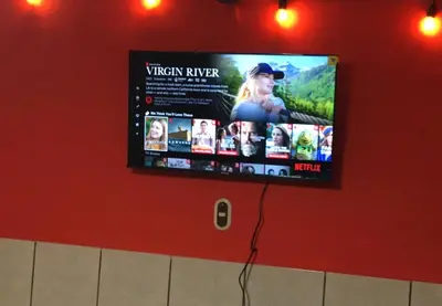 a flat screen tv on a red wall at Casa Topacio 1 in Santa Ana