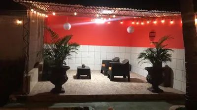 a room with a red wall with chairs and plants at Casa Topacio 1 in Santa Ana