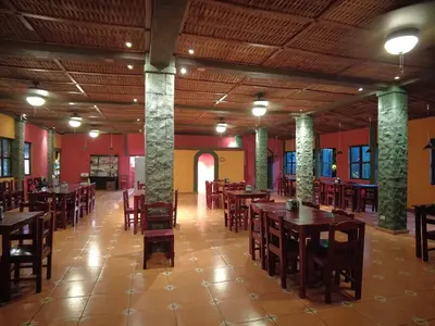 a restaurant with wooden tables and chairs in a room at El Castillo de Piedra in San Miguel