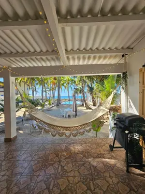a hammock on a patio with a view of the beach at Sunset Surf Villa in La Libertad