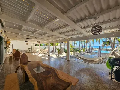 a living room with a table and a hammock at Sunset Surf Villa in La Libertad