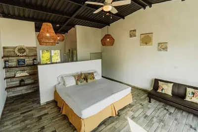 a bedroom with a bed and a couch at Ocean Paradise in Barra de Santiago