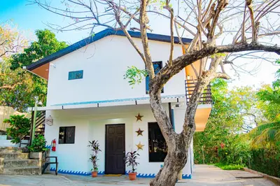 a white house with a blue roof at Buena Vista El Zonte in El Zonte