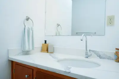 a white bathroom with a sink and a mirror at Buena Vista El Zonte in El Zonte