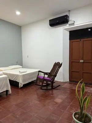 a room with a bed and a chair in it at Hostal El Amate #2 in Suchitoto