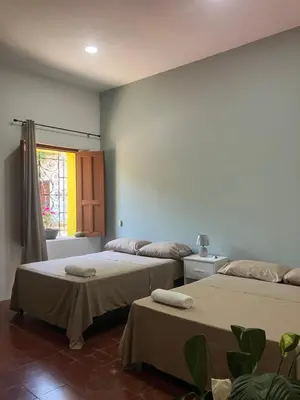 a room with two beds and a window at Hostal El Amate #2 in Suchitoto