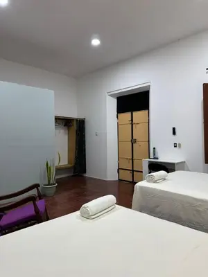two beds in a room with white walls at Hostal El Amate #2 in Suchitoto
