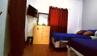 a bedroom with two beds and a television in it at costa azul apartment el zonte in La Libertad