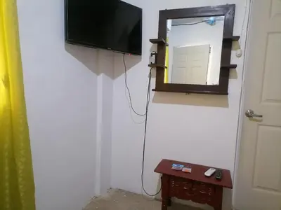 a television hanging on a wall next to a door at costa azul apartment el zonte in La Libertad