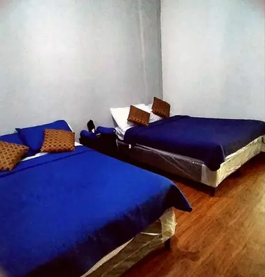 two twin beds in a room with blue sheets at costa azul apartment el zonte in La Libertad