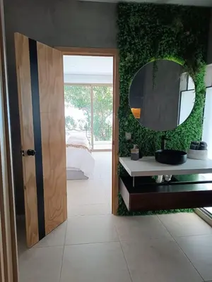 a bathroom with a mirror and a sink and a bed at Eco Sky Villas in El Sunzal