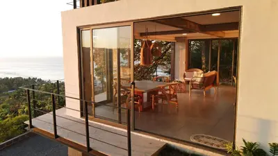a balcony of a house with a table and chairs at Eco Sky Villas in El Sunzal