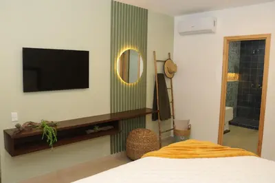 a bedroom with a bed and a tv and a mirror at Eco Sky Villas in El Sunzal