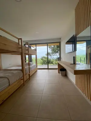 a bedroom with two bunk beds and a desk at Eco Sky Villas in El Sunzal