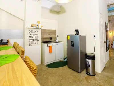 a kitchen with a refrigerator and a table in a room at Acogedor Loft, Playa Las Flores in La Libertad