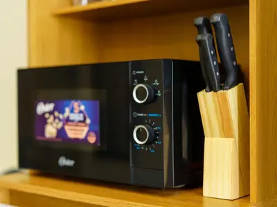 a black microwave with knives in front of it at Acogedor Loft, Playa Las Flores in La Libertad