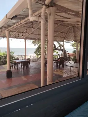 a view of a patio with a table and a view of the ocean at Chilamar Surf Lodge in La Libertad