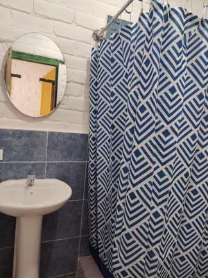 a bathroom with a blue and white shower curtain and a sink at Chilamar Surf Lodge in La Libertad