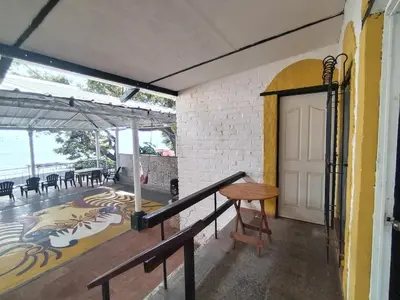 a room with a door and a table and chairs at Chilamar Surf Lodge in La Libertad
