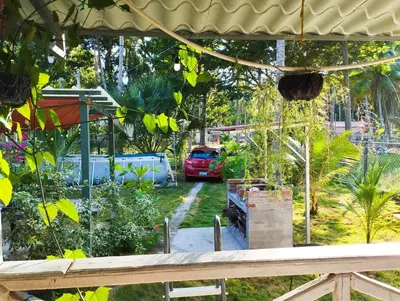 a garden with a red car parked in the yard at Casa Jaragua in Barra de Santiago