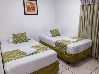 two beds in a hotel room withskirts at Suites & Apartments San Benito - Zona Rosa in San Salvador