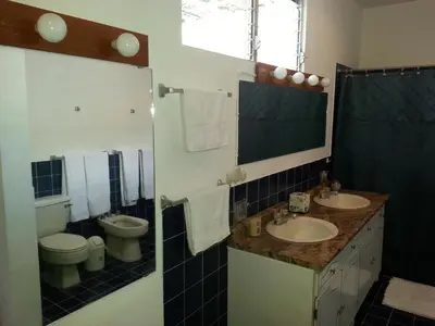 a bathroom with two sinks and a toilet at Suites & Apartments San Benito - Zona Rosa in San Salvador