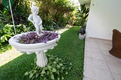 a statue of a girl sitting in a flower fountain at Suites & Apartments San Benito - Zona Rosa in San Salvador