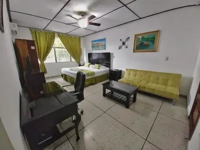 a living room with a bed and a couch at Suites & Apartments San Benito - Zona Rosa in San Salvador