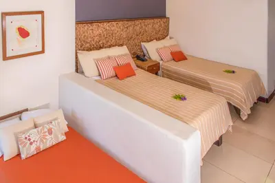 two beds in a room with orange and white at Las Flores Resort in Chirilagua