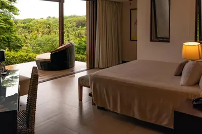 a bedroom with a bed and a chair and a window at Las Flores Resort in Chirilagua