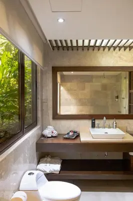 a bathroom with a sink and a toilet and a mirror at Las Flores Resort in Chirilagua