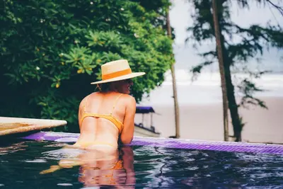 a woman in a hat in a swimming pool at Las Flores Resort in Chirilagua