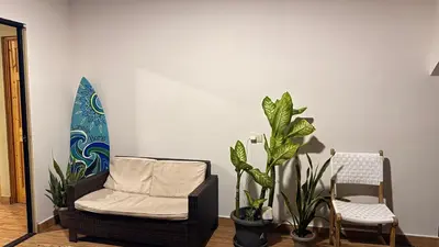 a living room with a chair and plants at Lomeli’s Home, 5 minutos del Tunco in La Libertad