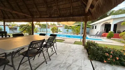 a patio with a table and chairs and a pool at Lomeli’s Home, 5 minutos del Tunco in La Libertad
