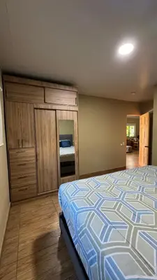 a bedroom with a bed with a blue and white comforter at Lomeli’s Home, 5 minutos del Tunco in La Libertad