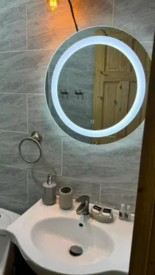 a bathroom sink with a circular mirror above it at Lomeli’s Home, 5 minutos del Tunco in La Libertad