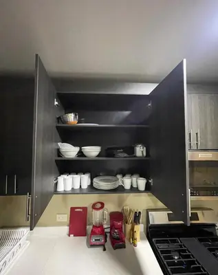 a kitchen with black cabinets and red appliances at Lomeli’s Home, 5 minutos del Tunco in La Libertad