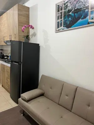 a living room with a couch and a refrigerator at Dream of angels home in Santa Ana