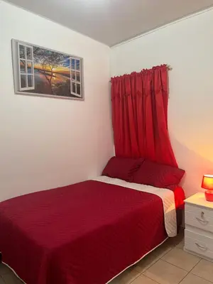 a bedroom with a red bed and a window at Dream of angels home in Santa Ana