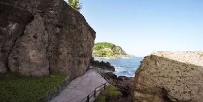 a stairway leading down to the ocean between two large rocks at Atami Escape Resort in La Libertad