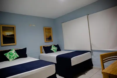 a room with two beds and a table in it at Atami Escape Resort in La Libertad