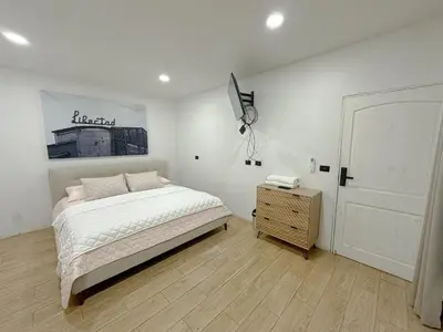 a white bedroom with a bed and a night stand at Casa Francisca in Alegría