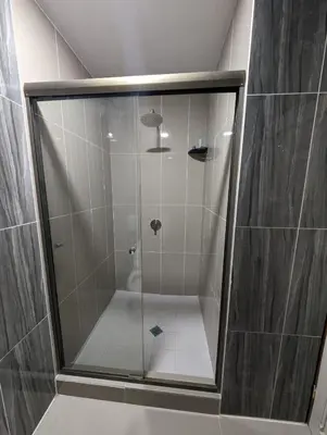 a shower with a glass door in a bathroom at Hotel Abrego in San Salvador