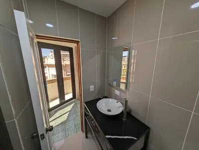 a small bathroom with a sink and a window at Hotel Abrego in San Salvador