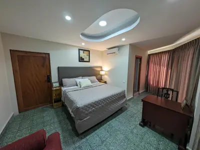 a bedroom with a bed and a desk and a bed sidx sidx sidx at Hotel Abrego in San Salvador
