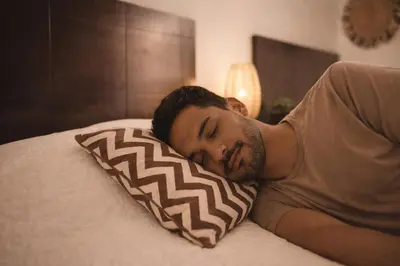 a man laying on a bed with a pillow at Habitación Deluxe Tierra - Villa Valle Campo in Nahuizalco