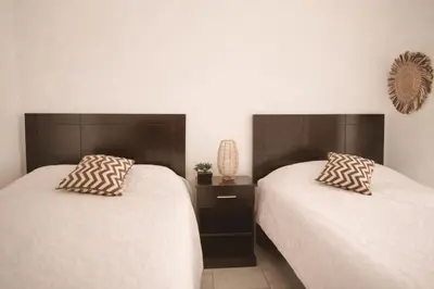 two beds sitting next to each other in a room at Habitación Deluxe Tierra - Villa Valle Campo in Nahuizalco