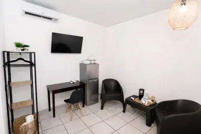 a living room with a desk and a television on a wall at Habitación Deluxe Tierra - Villa Valle Campo in Nahuizalco