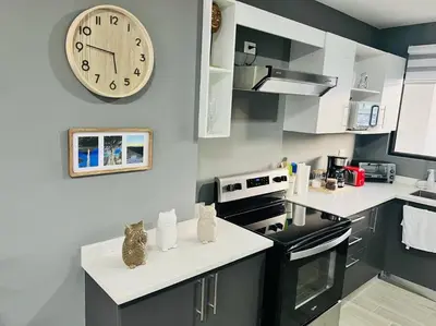 a kitchen with a large clock on the wall at Elegante y acogedor apartamento en el corazón de San Salvador in San Salvador